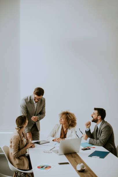 istock Group of young business people working and communicating while sitting at the office desk together 1315491502