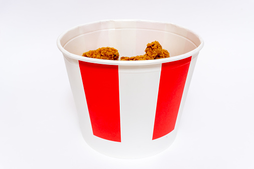 Deep fried spicy chicken wings in a crispy breading in a cardboard basket, chicken fast food isolated on white background. High quality photo