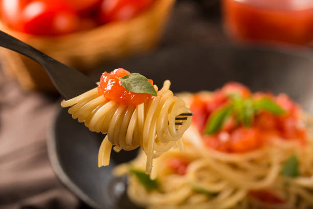 Spaghetti with tomato sauce, basil and red wine. Close up image, shallow focus, vibrant image.
