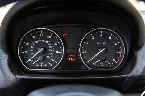 Speedometer and odometer readout for driver of luxury car with temperature and time display.