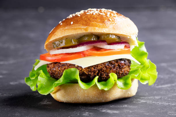 istock Cheeseburger on a black stone background. Hamburger with cheese. Burger isolated. Tasty Dinner.Copy space. 1315506764