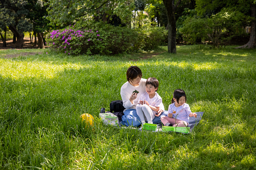 Young mother playing with her three children at home and at public park.