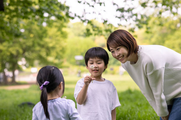 istock Young family playing with dandelion in public park 1315510740