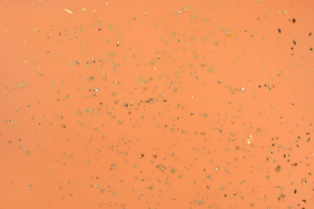 istock Falling Golden confetti on orange trendy background. 1315513946