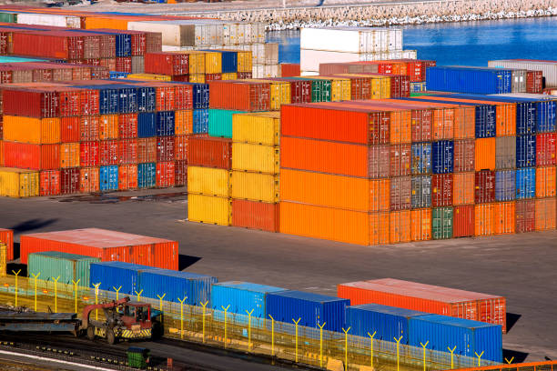 istock container terminal port warehouse with export cargo stockpiled and transported by truck with trailer stacks of multi-colored iron containers brokerage services, nobody. 1315536788
