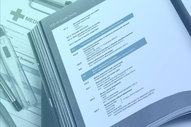 medical code handbook opens on doctor's desk use for classification of diseases to given code in medical record. - instruction manual imagens e fotografias de stock