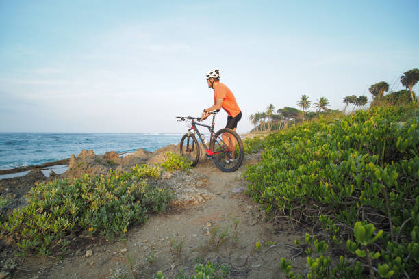 istock Man with mountain bike enjoying ocean view. Wide angle. 1315536979
