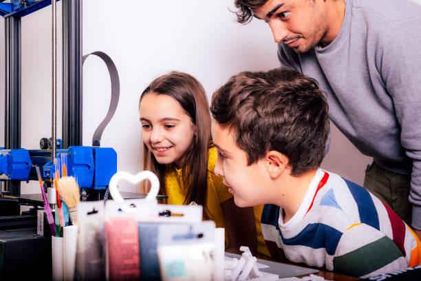 Children learning to 3D print with a young adult