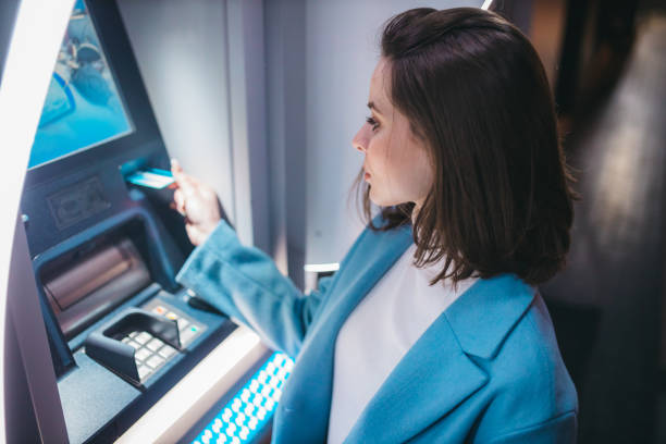 istock Beautiful woman using ATM machine on the street 1315539515