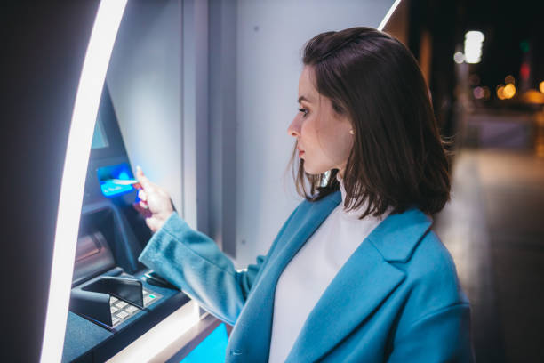 istock Beautiful woman using ATM machine on the street 1315539570
