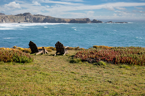 Adirondack chairs on bluff by ocean in  northern California on a sunny day