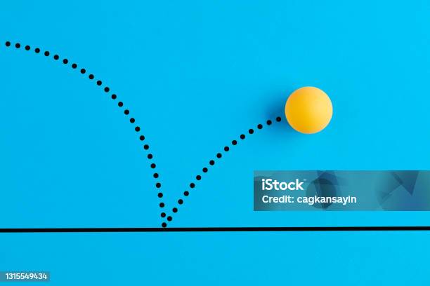 Bouncing Table Tennis Ball Is On Blue Background Stock Photo - Download Image Now - Bouncing, Sphere, Sports Ball