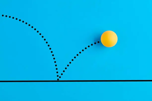 Photo of Bouncing table tennis ball is on blue background.