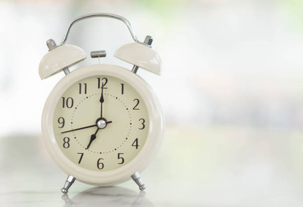 istock Alarm clock on white table with soft light in the morning, selective 1315554620