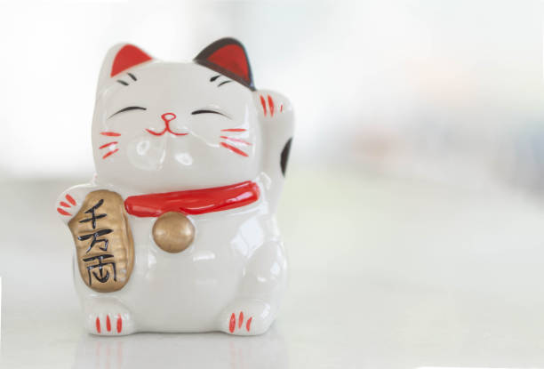 istock Maneki neko lucky cat show text on hand meaning rich on table, select focus 1315554873