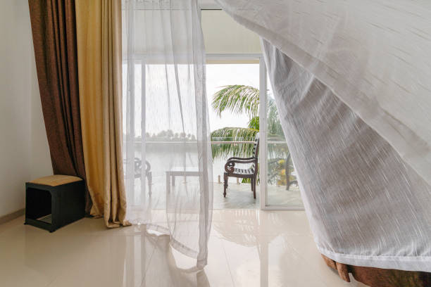 istock Wind moving curtains on the open balcony window with the scenic view on a river from the modern empty hotel room. 1315555923