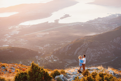 Couple hugging on the background of the panorama of Lovcen mount , Montenegro. High quality photo