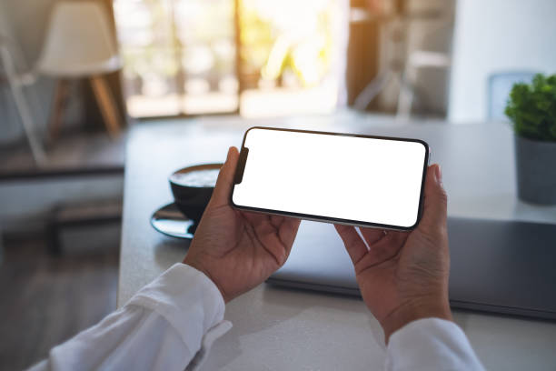 istock a woman holding mobile phone with blank white desktop screen 1315571040