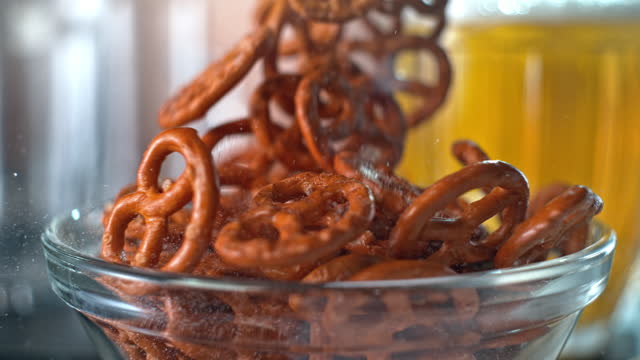 SLO MO Salted pretzels falling into a bowl