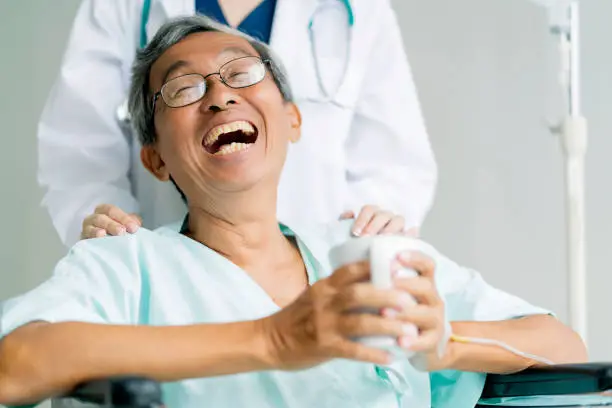 happiness senior asian patient big smile satisfaction with doctor hospital insurance service and takecare asian old male peaceful hand hold hot drink on wheel chair hospital background health concept