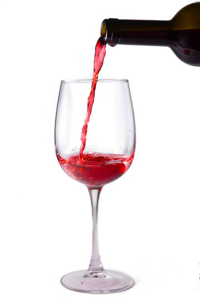 istock Red wine is poured into a glass from a bottle, isolate on a white background 1315573744
