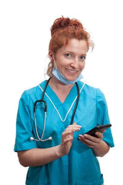 Portrait of female doctor with smartphone in hands on isolated white background stock photo