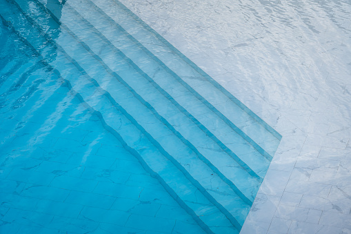 Piscina con agua azul transparente y suelo de lujo de mármol blanco. photo