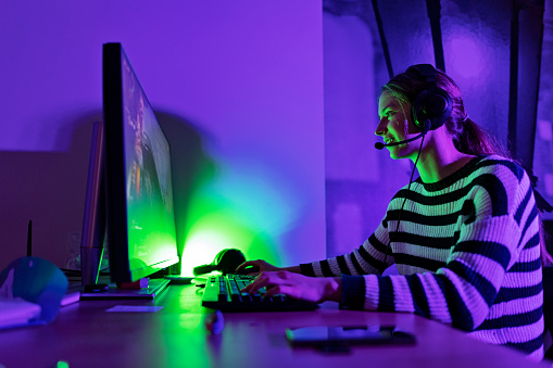 Teenage girl playing team multiplayer video games using desktop PC. 
Canon R5