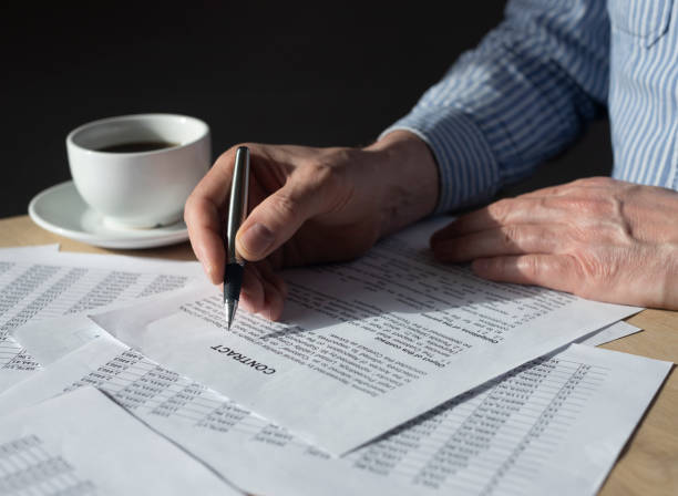 istock Man reading contract to sign it at office desk 1315606689