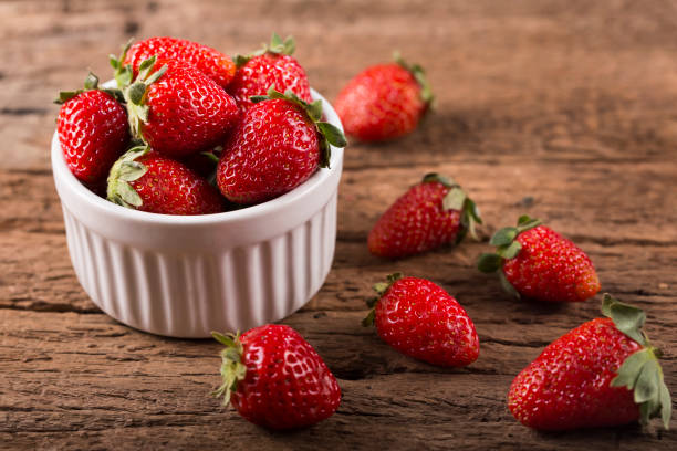 istock Fresh strawberries on rustic wooden background. 1315615523