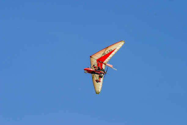 February 22, 2021 Kaliningrad, Russia White sport hang glider against the blue sky above a frozen bay