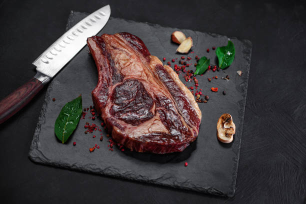 istock Raw pickled meat beef steak with spices on black stone background 1315622305