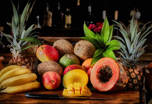 istock Tropical fruits in rustic kitchen: Wooden crate with assorted mangos and mango slice on cutting board. Natural lighting 1315625025