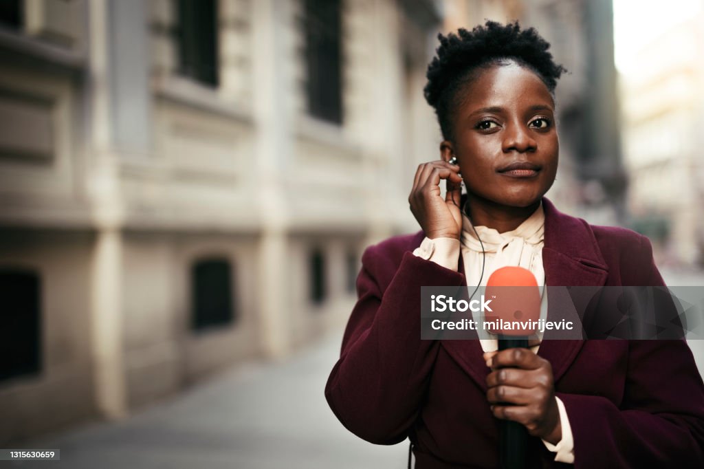TV reporter presenting the news outdoors. African female news reporter in live broadcasting. TV reporter presenting the news outdoors. Journalist Stock Photo