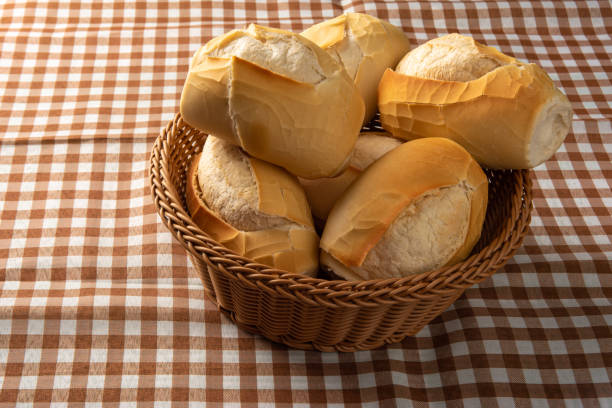 istock breads in a basket on checkered tablecloth over rustic wood, black background, selective focus. 1315630748