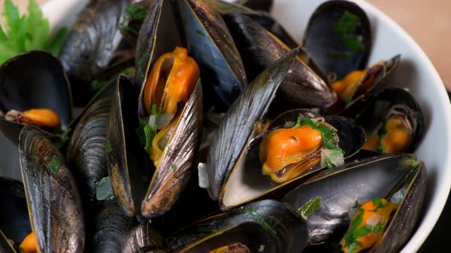 Moules mariniere, mussels, with cream, garlic and parsley in a iron bowl., Delicious French food,