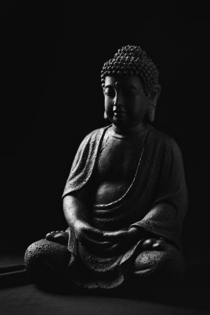 istock Meditating Buddha Statue on dark background. Copy space. 1315633699