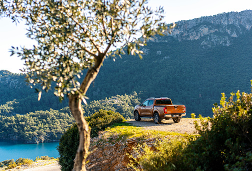 Mugla, Turkey - 10th, February, 2020: Nissan NP300 Navara stopped on the hill near the beach in Dalaman, Turkey. The newest generation of Navara was debut in 2015 on the market. The Navara is powered by 2,3-litre diesel engine and 190 HP