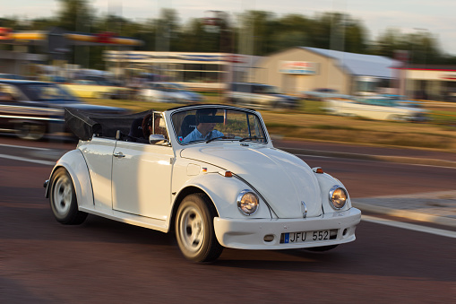 Rattvik, Sweden - July 27, 2013: Classic Car Week Rattvik - White VW Beetle, cabriolet. Car in motion blur.