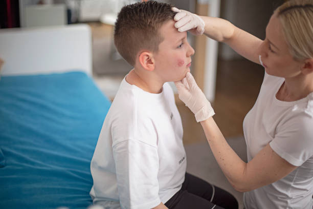 istock Mother cleaning her son's wound on his cheek 1315642106