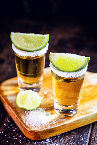 tequila d'oro con limone accanto a una botte di quercia, bevanda messicana - tequila shot tequila salt lemon foto e immagini stock
