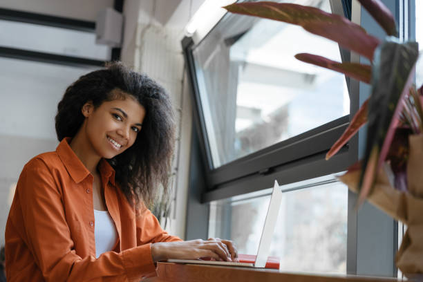 istock Smiling African American woman using laptop computer working freelance project from home. Successful business 1315650902