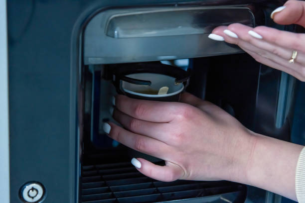 la femme ramasse le café du distributeur automatique - vending machine coin machine coin operated photos et images de collection