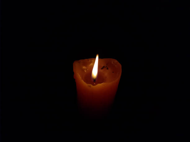 istock Candle burning in the dark, yellow flame 1315656114