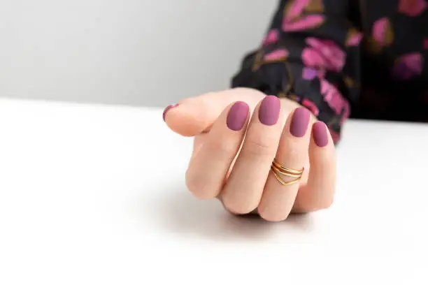 Photo of Beautiful womans hands with purple burgundy matte manicure