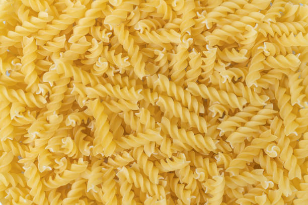 istock Uncooked or dry fusilli type of pasta textured background. 1315676247