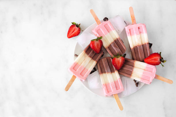 istock Group of neapolitan popsicles on a plate against white marble 1315676357