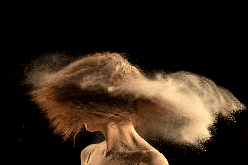 Dancer making hair trail with powder