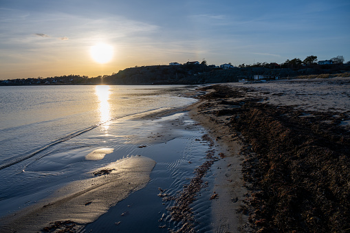 A beautiful orange sunset over an ocean bay. Thee sun reflects in the water. Picture from the Swedish west coast