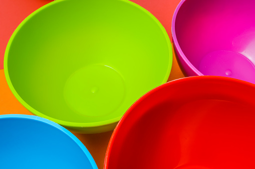 narrow view of a colorful group of plastic bowls - abstract colorful background